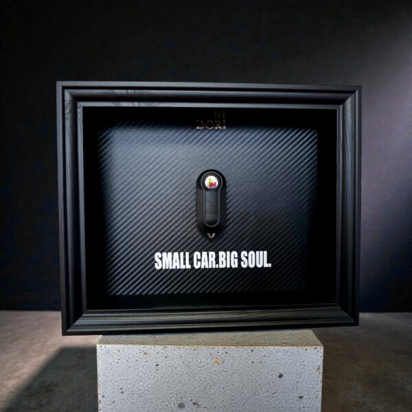 Automobilio raktelio dekoratyvinis paveikslas su anglies pluošto fonu ir užrašu „Small Car. Big Soul.“