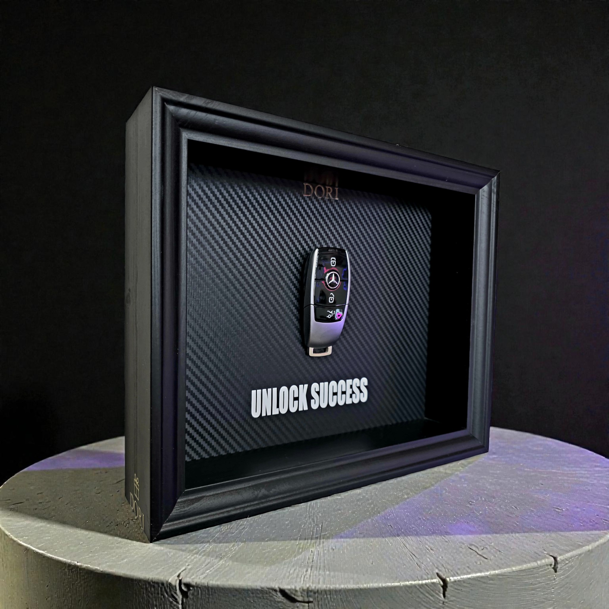 Automobilio raktelio dekoratyvinis paveikslas su anglies pluošto fonu ir užrašu „Unlock Success“