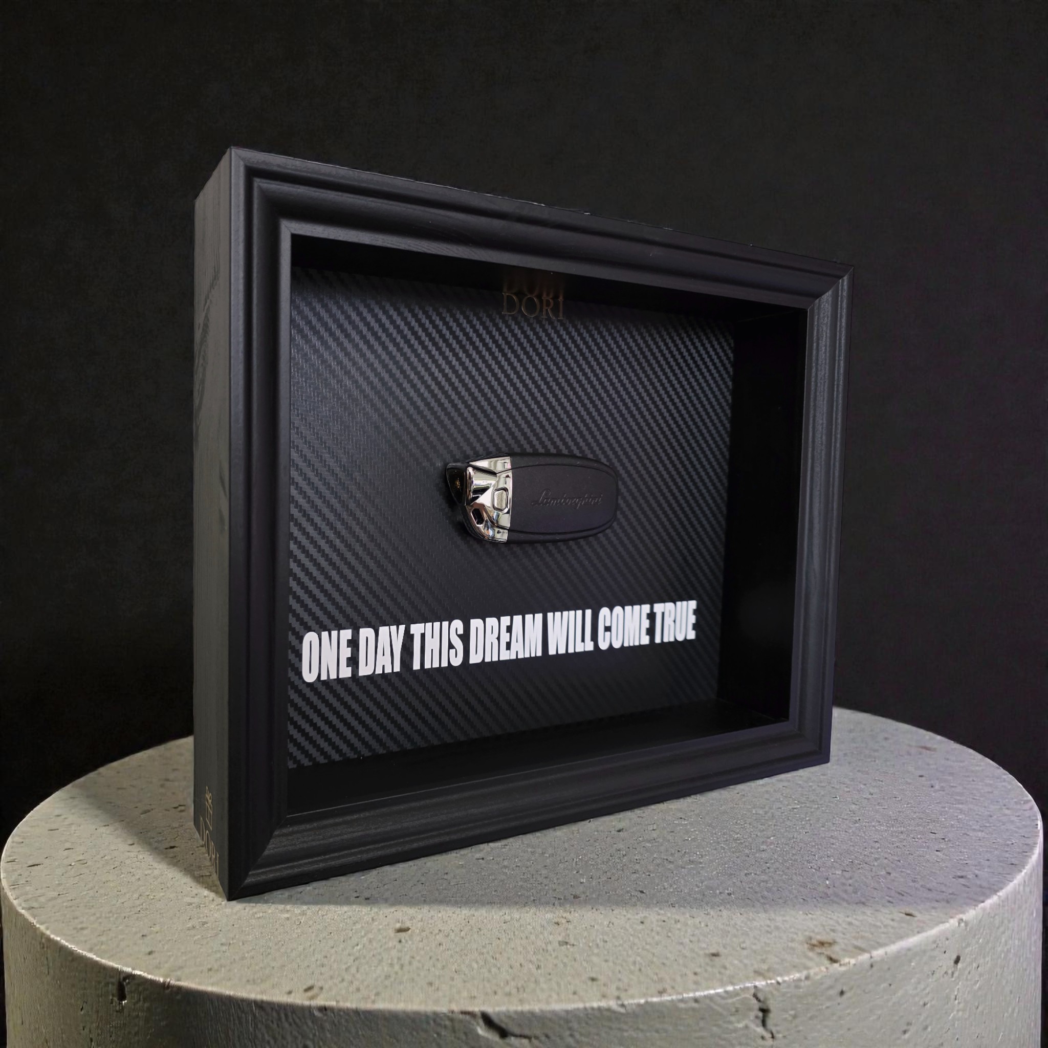 Automobilio raktelio dekoratyvinis paveikslas su anglies pluošto fonu ir užrašu „One Day This Dream Will Come True“