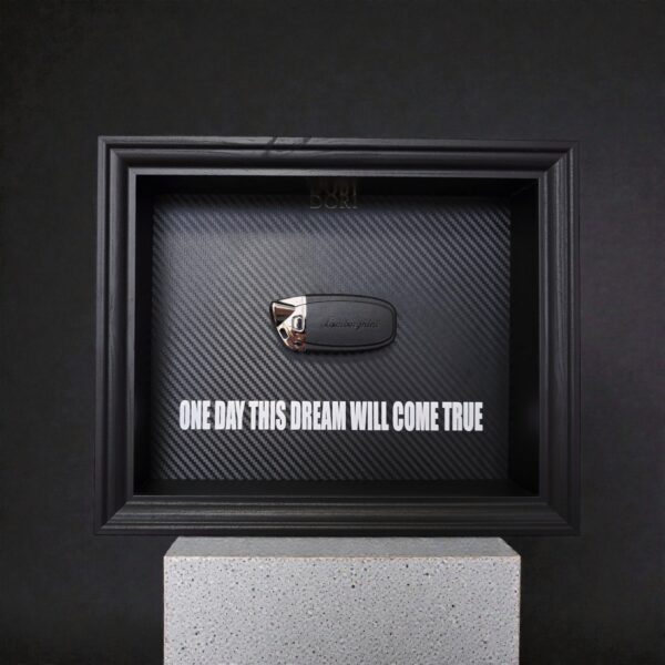 Automobilio raktelio dekoratyvinis paveikslas su anglies pluošto fonu ir užrašu „One Day This Dream Will Come True“