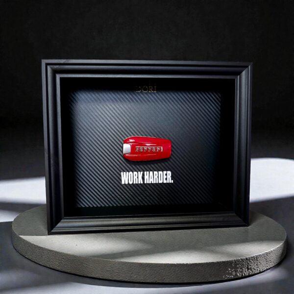 Automobilio raktelio dekoratyvinis paveikslas su anglies pluošto fonu ir užrašu „Work Harder“