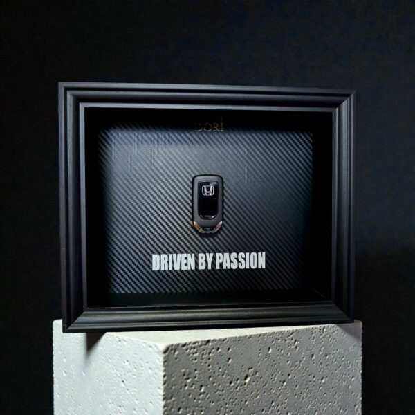 Automobilio raktelio dekoratyvinis paveikslas su anglies pluošto fonu ir užrašu „Driven by Passion“