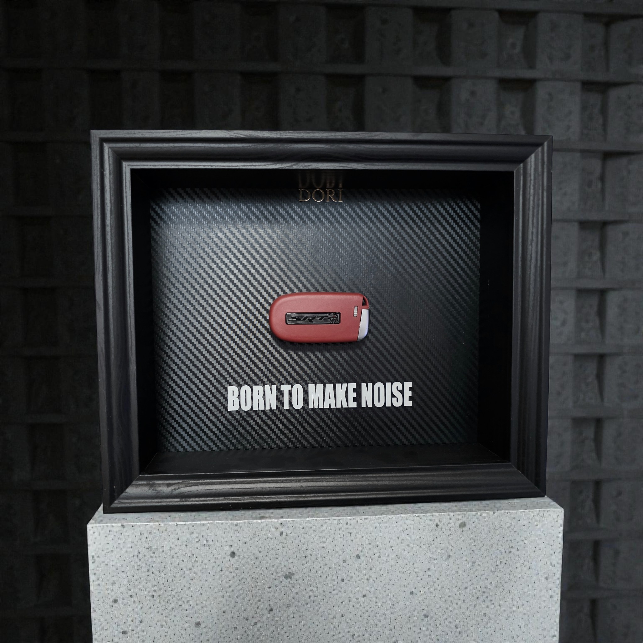 Automobilio raktelio dekoratyvinis paveikslas su anglies pluošto fonu ir užrašu „Born to Make Noise“