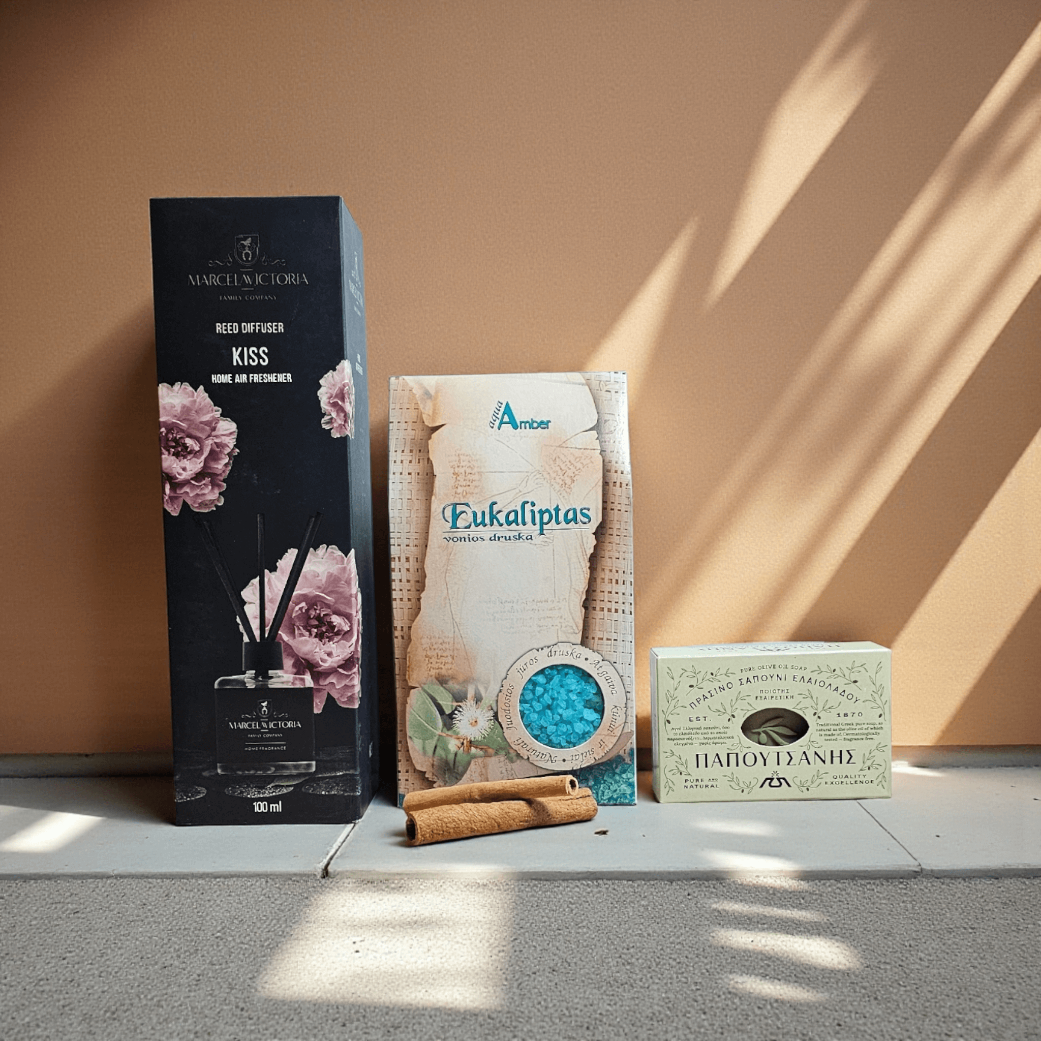 DORI aromaterapijos rinkinys su namų kvapikliu, eukalipto vonios druska ir natūraliu muilu, fotografuotas šiltame minimalistiniame fone.