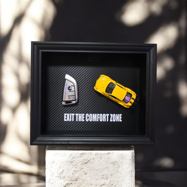 DORI motyvacinis paveikslas su BMW rakteliu ir fraze Exit The Comfort Zone