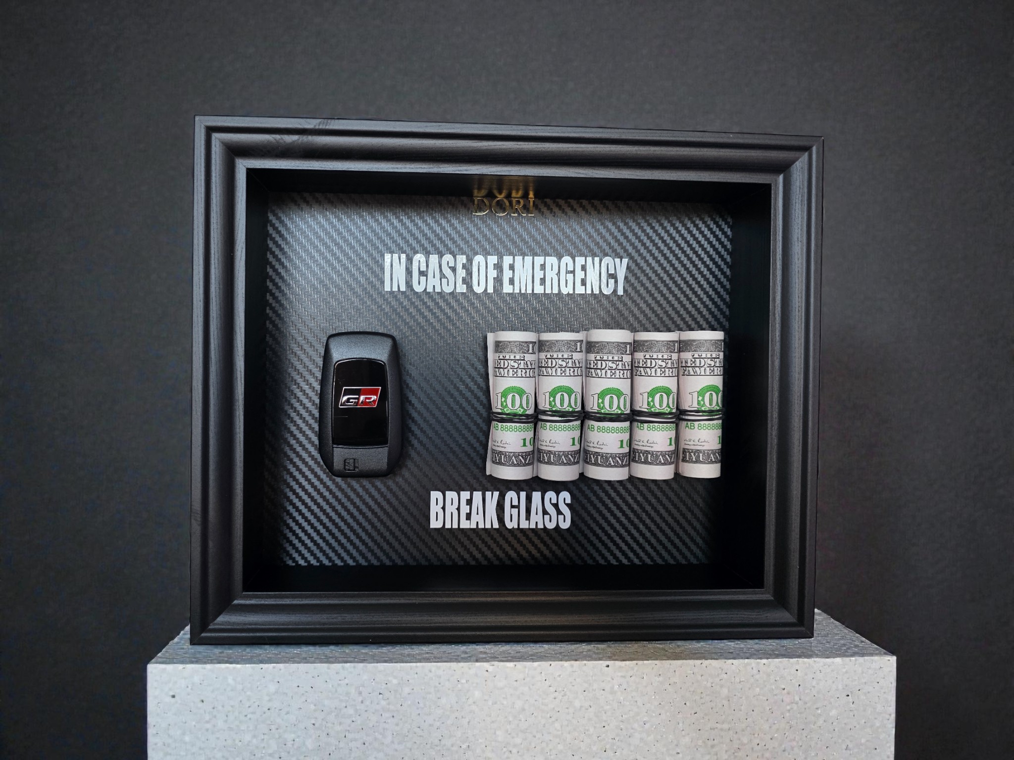 Toyota GR automobilio raktelis ir pinigai motyvaciniame paveiksle „Break Glass“ juodame rėme