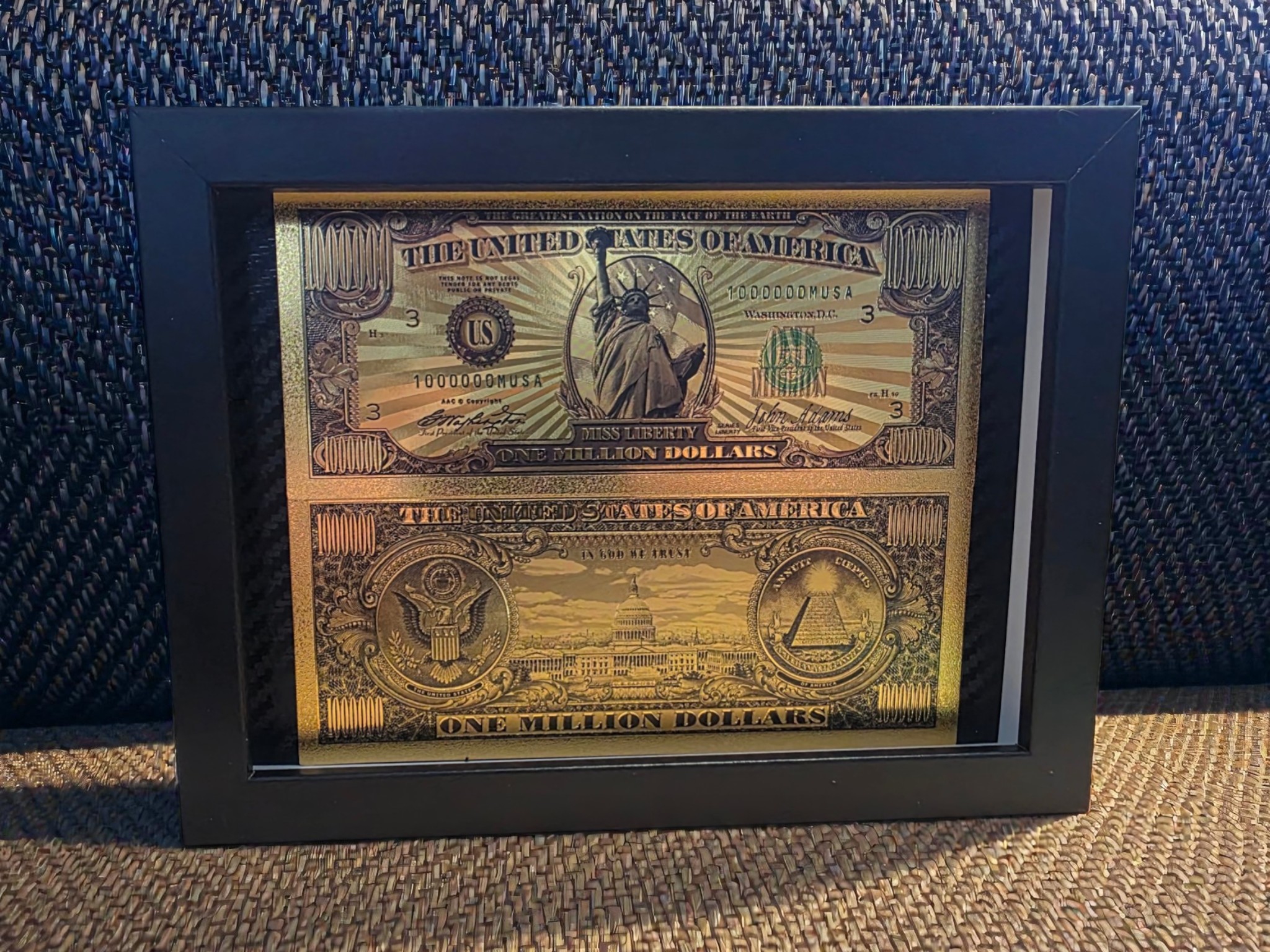 Auksinis „One Million Dollars“ paveikslas juodame rėme